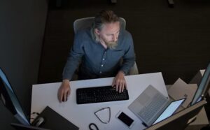 An IT pro at his computer in a dark office